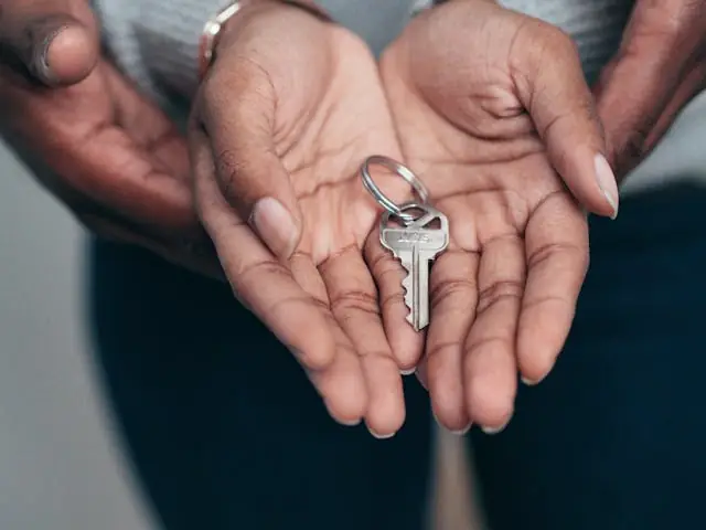 A person holding a home key in their hands